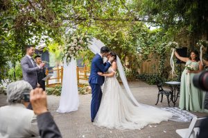 Bride and groom kiss under the glass canopy at Madison Greenhouse
