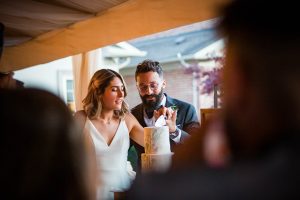 Cutting the cake at backyard wedding reception