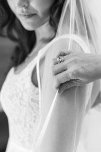 Close-up of bride’s veil being adjusted by her mother, showing detail in lace fabric