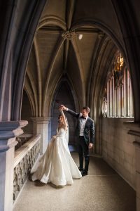 Groom twirls the bride under a vaulted ceiling at Knox College wedding.