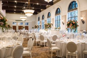 Reception space at Liberty Grand decorated with tall floral centerpieces in blush tones.
