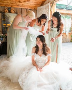 Bridesmaids naturally putting veil on bride at Madison Greenhouse